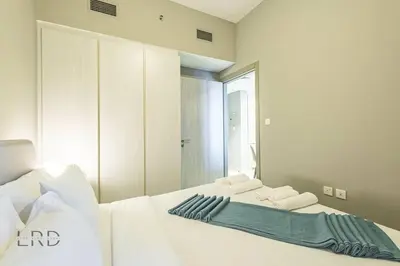 a bedroom with a white bed with a mirror at Cozy & Radiant 1BR Business Bay in Dubai