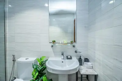 a white bathroom with a sink and a toilet at Escape24 Cozy 1BR near Dubai Malll & Burj Khalifa in Dubai