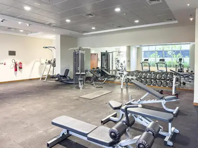 a gym with several treadmills and cardio machines at Escape24 Cozy 1BR near Dubai Malll & Burj Khalifa in Dubai