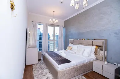 a bedroom with a large bed and a large window at Escape24 Cozy 1BR near Dubai Malll & Burj Khalifa in Dubai