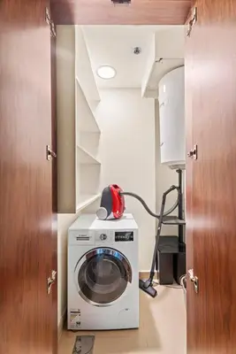 a laundry room with a washing machine in a room at Luxe 3BR Retreat, Balcony Burj & Fountain Views, Prime Downtown Stay in Dubai