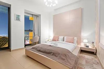 a white bedroom with a large bed and a window at Luxe 3BR Retreat, Balcony Burj & Fountain Views, Prime Downtown Stay in Dubai