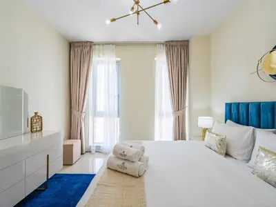 a white bedroom with a large bed and a tv at Downtown Luxury Living -1BR-Standpoint Tower A in Dubai