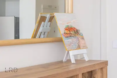 a painting on a stand in front of a mirror at Modern & Vibrant 1BR Dubai Hills in Dubai