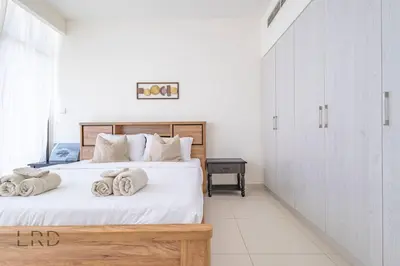 a bedroom with a bed with towels on it at Modern & Vibrant 1BR Dubai Hills in Dubai
