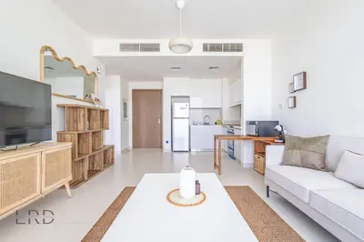 a living room with a couch and a table at Modern & Vibrant 1BR Dubai Hills in Dubai