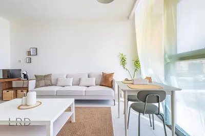 a living room with a couch and a table at Modern & Vibrant 1BR Dubai Hills in Dubai