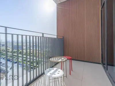 a balcony with a table and two stools at Modern & Vibrant 1BR Dubai Hills in Dubai