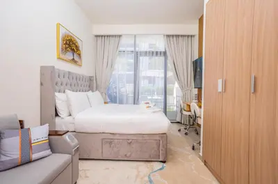 a bedroom with a bed and a couch and a window at Zapbed House - Modern Studio in Azizi Riviera 27 Meydan One in Dubai