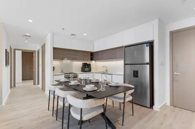 a kitchen with a table and chairs and a refrigerator at Luxury 2 bedroom in Dubai Creek Harbour- Suiteable in Dubai