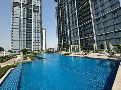a large swimming pool with two tall buildings at Luxury 2 bedroom in Dubai Creek Harbour- Suiteable in Dubai