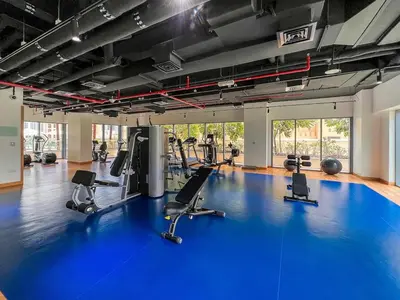 a gym with a blue gym floor with treadmills at Iconic Burj Khalifa Views from Luxury 1BR Home in Dubai