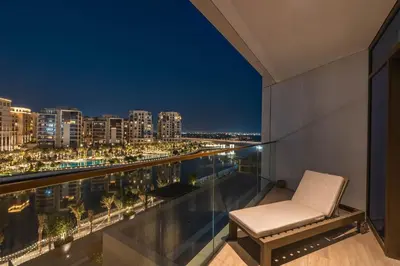 a chair on a balcony with a view of the city at GuestReady - Upscale living at Palace Residence in Dubai