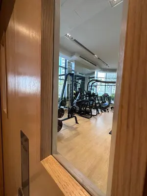 a mirror reflection of a gym with exercise equipment at Modern Comfort1BR RP Heights 5-min Dubai Mall in Dubai
