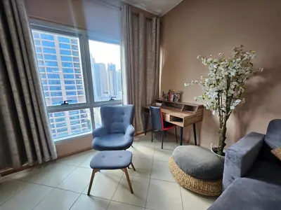 a living room with a blue couch and a table and a window at Stunning Apartment, Partial Sea View, Canal Marina View, 5 min walk To JBR Beach and METRO in Dubai