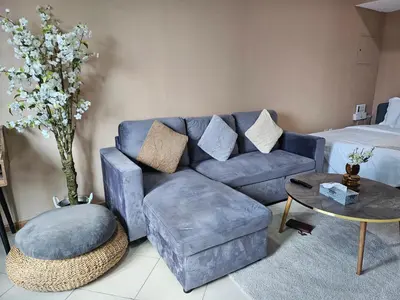 a living room with a blue couch and a table at Stunning Apartment, Partial Sea View, Canal Marina View, 5 min walk To JBR Beach and METRO in Dubai