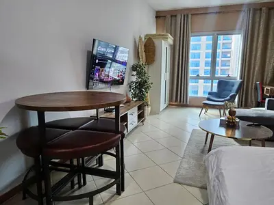a living room with a table and a tv at Stunning Apartment, Partial Sea View, Canal Marina View, 5 min walk To JBR Beach and METRO in Dubai