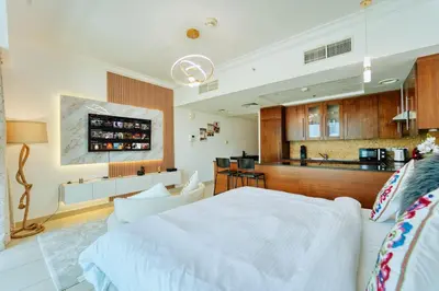a bedroom with a large white bed and a kitchen at Luxury Studio - Downtown Dubai 6 Minute Walk to Burj Khalifa & Dubai Mall in Dubai