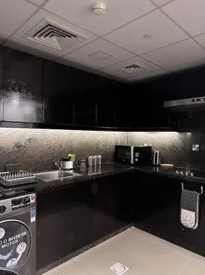 a kitchen with black cabinets and a counter top at Luxury sea-view apartment in Dubai