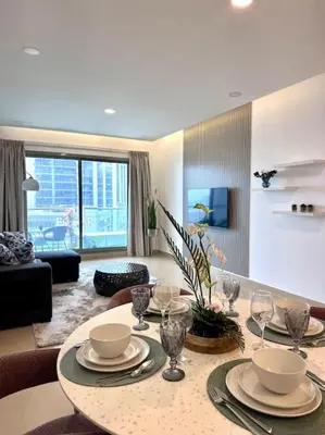 a living room with a table with plates and wine glasses at Luxury sea-view apartment in Dubai