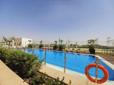 a large swimming pool with a red ring in the middle at Charming Studio at Azizi Riviera 32, Al Merkadh by Deluxe Holiday Homes in Dubai