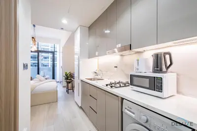 a kitchen with a microwave and a stove top oven at Charming Studio at Azizi Riviera 32, Al Merkadh by Deluxe Holiday Homes in Dubai