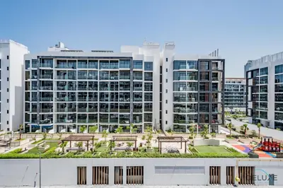 a group of buildings with benches in front of them at Charming Studio at Azizi Riviera 32, Al Merkadh by Deluxe Holiday Homes in Dubai