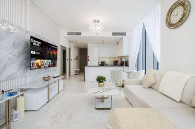a living room with a white couch and a kitchen at Luxury Apt Burj Khalifa, Sunset and Lagoon view in Dubai
