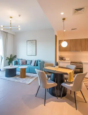 a living room with a blue couch and a table at Offer! 1BR, Skyline View, Dubai Hills Estate, Park Ridge in Dubai