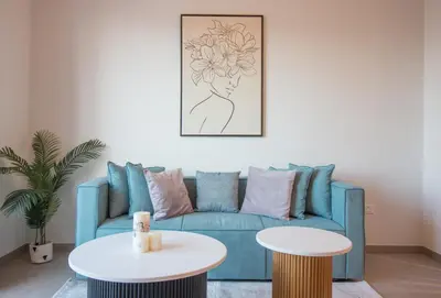 a living room with a blue couch and a table at Offer! 1BR, Skyline View, Dubai Hills Estate, Park Ridge in Dubai