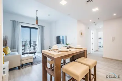 a kitchen and living room with a table and chairs at Delightful 2BR Apartment in Town Square Safi 1A, Dubailand by Deluxe Holiday Homes in Dubai
