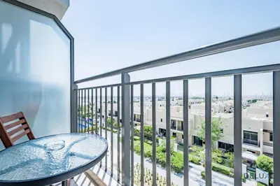a balcony with a table and a view of a city at Delightful 2BR Apartment in Town Square Safi 1A, Dubailand by Deluxe Holiday Homes in Dubai