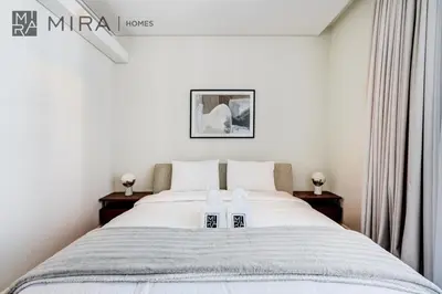 a bedroom with a large bed with two night stands at Mira Holiday Homes - Luxury 2 bedroom in Bluewaters with stunning view in Dubai