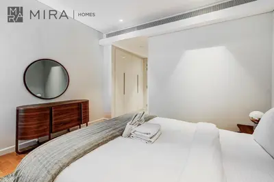 a bedroom with a large white bed and a mirror at Mira Holiday Homes - Luxury 2 bedroom in Bluewaters with stunning view in Dubai