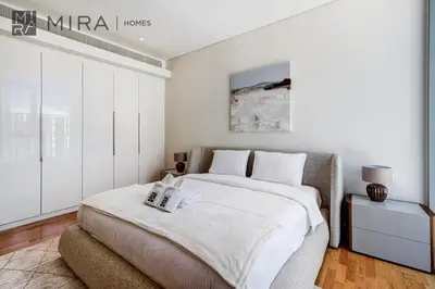 a white bedroom with a large bed with white walls at Mira Holiday Homes - Luxury 2 bedroom in Bluewaters with stunning view in Dubai