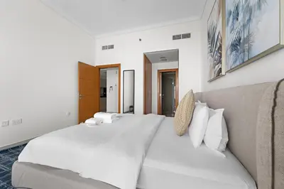 a bedroom with a large white bed and a couch at StoneTree - High Floor - Prime location in Dubai