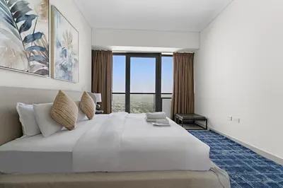 a bedroom with a large white bed with a large window at StoneTree - High Floor - Prime location in Dubai