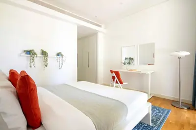 a bedroom with a white bed and a desk at Frank Porter - Bluewaters Residences Building 5 in Dubai