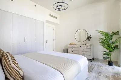 a bedroom with a bed and a mirror and a dresser at Frank Porter - Park Point Building C in Dubai