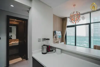 a kitchen with a white counter and a large window at Queens Estate Vacation Homes - Merano Tower, Business Bay in Dubai