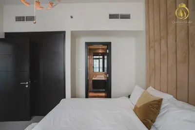 a bedroom with a white bed and a black door at Queens Estate Vacation Homes - Merano Tower, Business Bay in Dubai