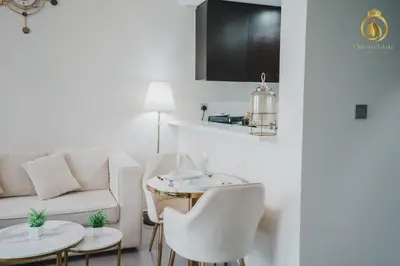 a living room with a couch and a table and chairs at Queens Estate Vacation Homes - Merano Tower, Business Bay in Dubai