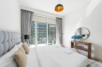 a bedroom with a bed and a mirror and a window at Spacious 2 BHK next to the Beach - Sunrise Bay in Dubai