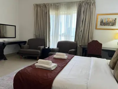 a hotel room with a bed with two towels on it at ASHRI HH, Studio in JVC Dana Tower in Dubai