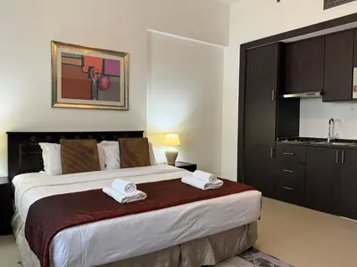 a bedroom with a large bed with two towels on it at ASHRI HH, Studio in JVC Dana Tower in Dubai