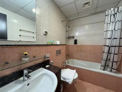 a bathroom with a sink and a tub and a toilet at ASHRI HH, Studio in JVC Dana Tower in Dubai