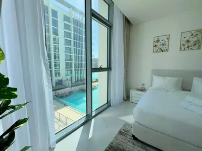 a bedroom with a bed and a large window at Spacious 1bedroom W Lagoon In Al Maktoum City in Dubai
