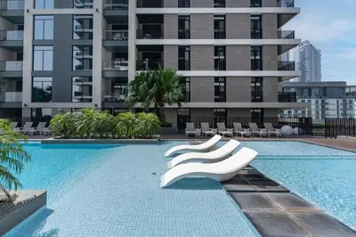 a swimming pool with white chairs and a building at Wilton Terraces T1 - 1BR Apartment - Allsopp&Allsopp in Dubai
