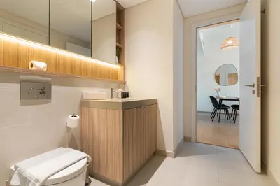 a bathroom with a toilet and a table at Wilton Terraces T1 - 1BR Apartment - Allsopp&Allsopp in Dubai