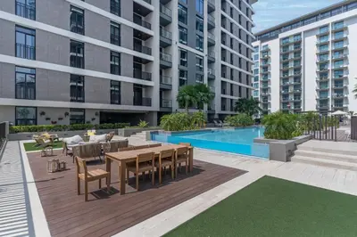 an apartment patio with a table and chairs and a pool at Wilton Terraces T1 - 1BR Apartment - Allsopp&Allsopp in Dubai